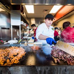 A grill cook works her magic at Taco Ssam. 