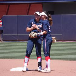 Reyna Carranco and Mo Mercado high five before an inning starts
