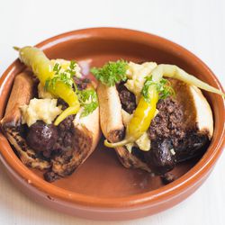 Mini morcilla hot dogs with blood sausage Bolognese, spicy mustard, and turmeric onions