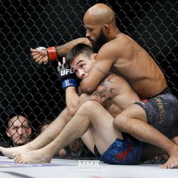 Demetrious Johnson looks for early submission.