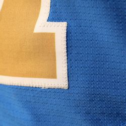 A close-up of the front of the jersey shows the stitching for the number.