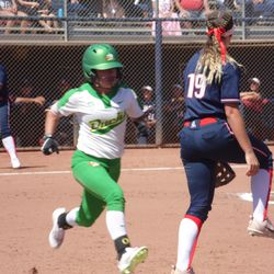Jessie Harper hops off the bag as an Oregon hitter reaches first base