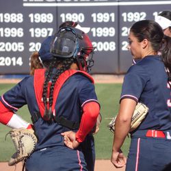 Danielle O’Toole, Dejah Mulipola, and Stacy Iveson meet in the pitcher’s circle