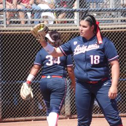 Taylor McQuillin receives a ball from catcher Dejah Mulipola