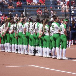 Oregon stands on the first base line before Saturday’s game