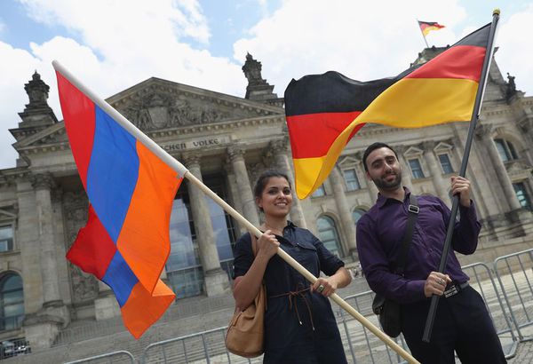 Supporters of the vote wave German and Armenian flags outside the Bundestag.