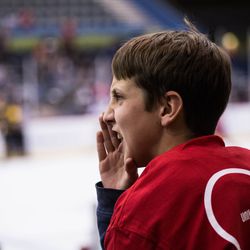 A young fan gets into the game by joining the chants during the first period