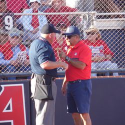 Mike Candrea argues with the umpire