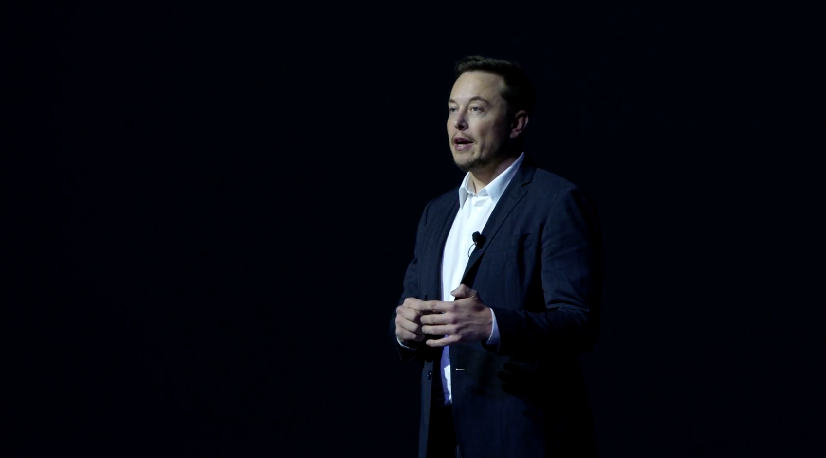 Elon Musk giving a speech to an audience.